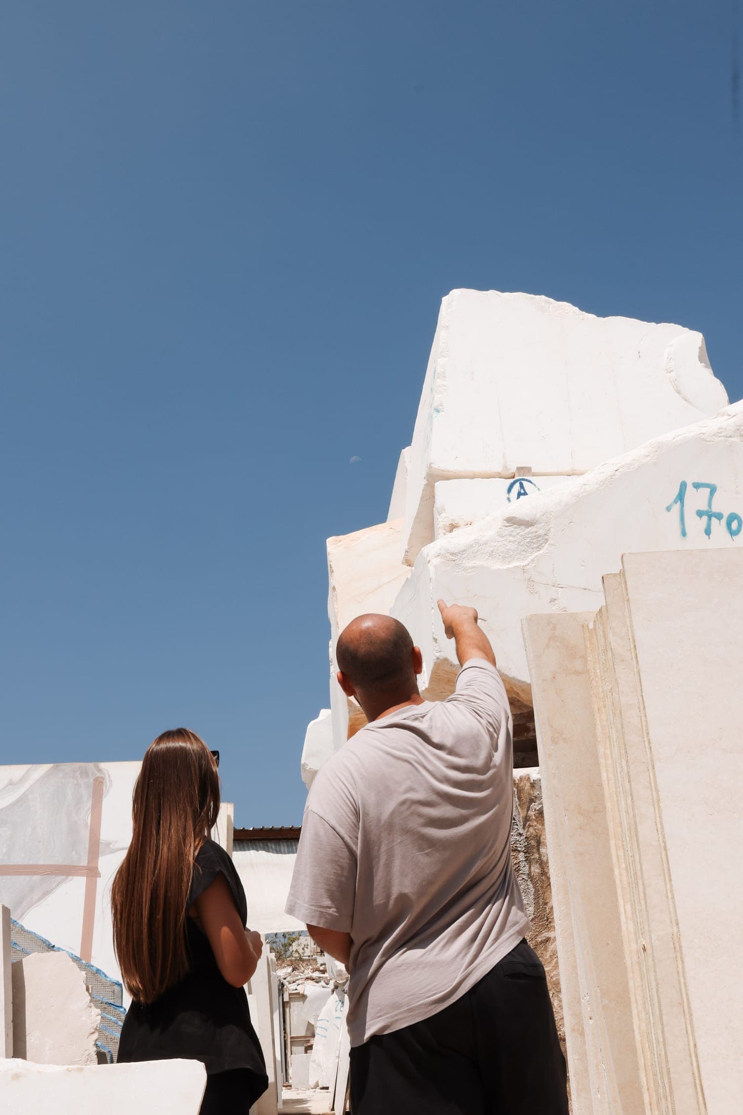 Two members of the Zein Group team pointing out a block in the marble yard, Beirut