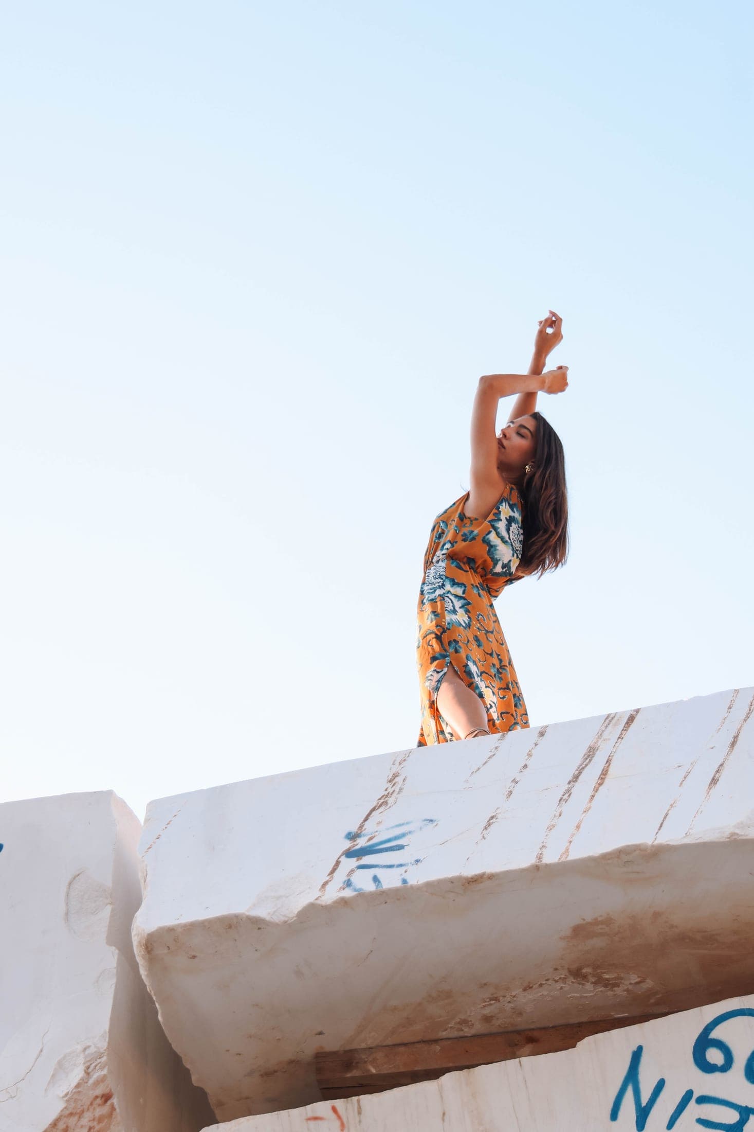 A figure on top of a marble block, arm raised to the sky