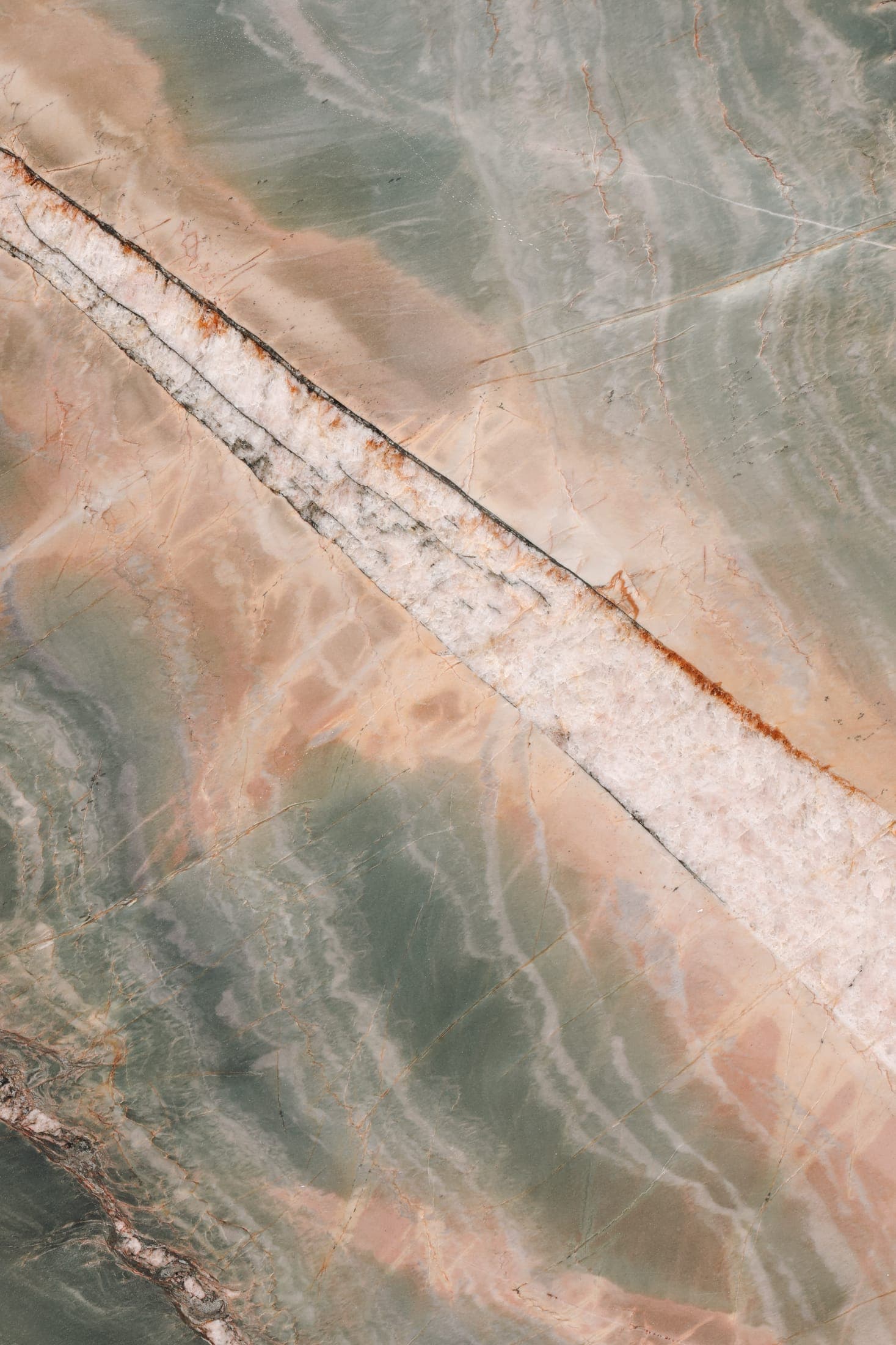 Close-up of a polished green and ochre stone slab with a crystalline surface at the Zein Group stone yard