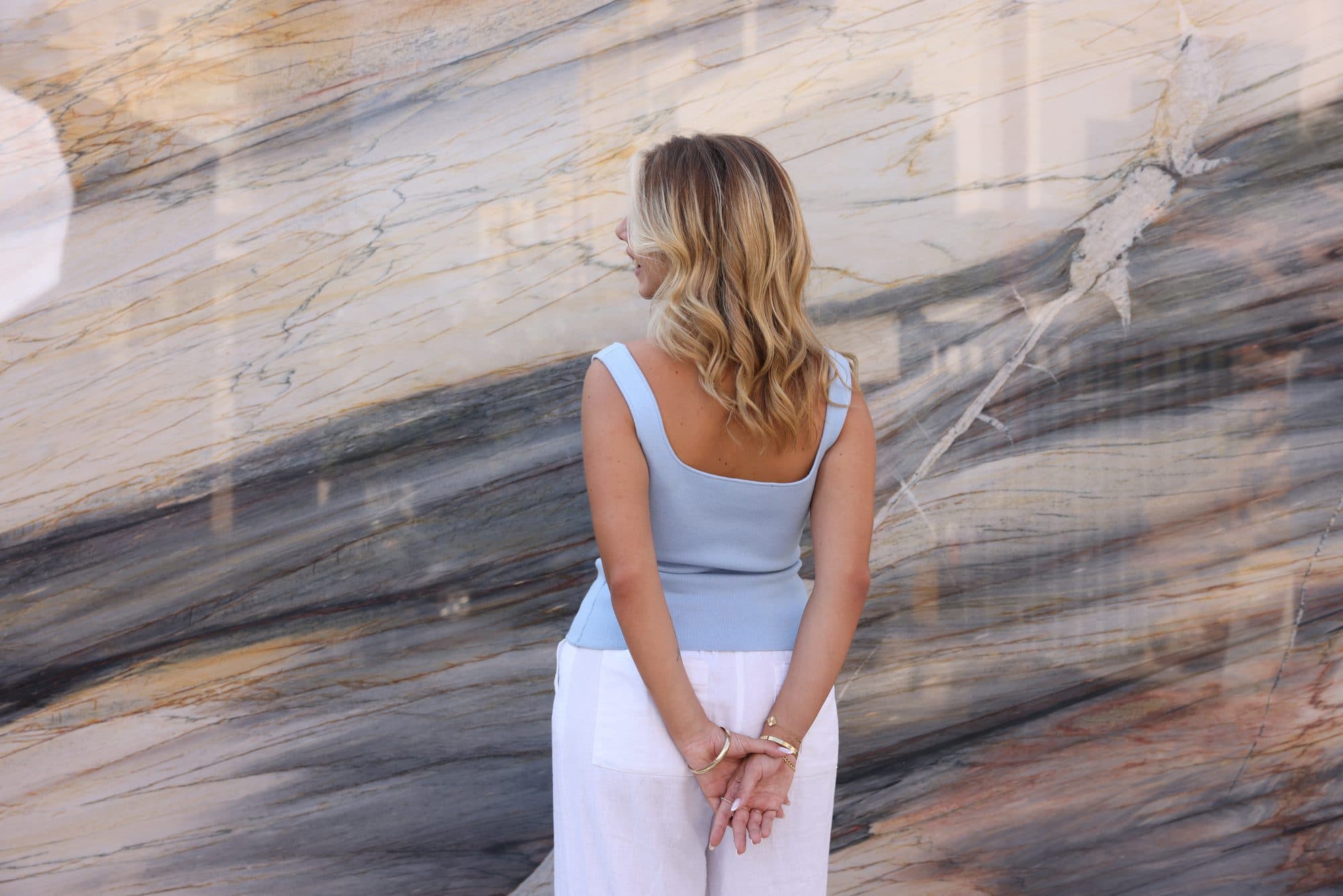 A figure before a dramatic blue-grey marble feature wall