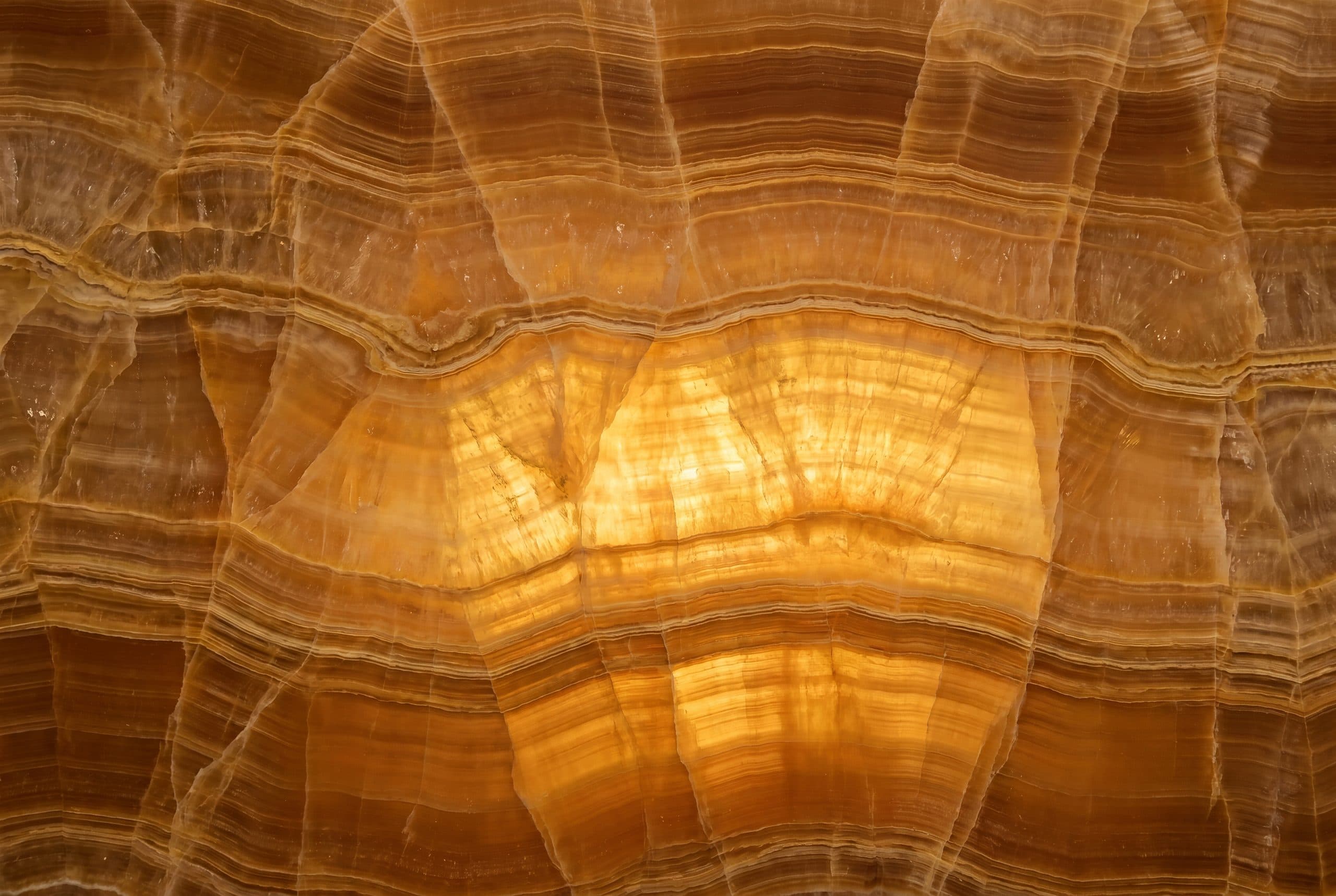 Backlit golden onyx with warm amber and honey veining — Zein Group