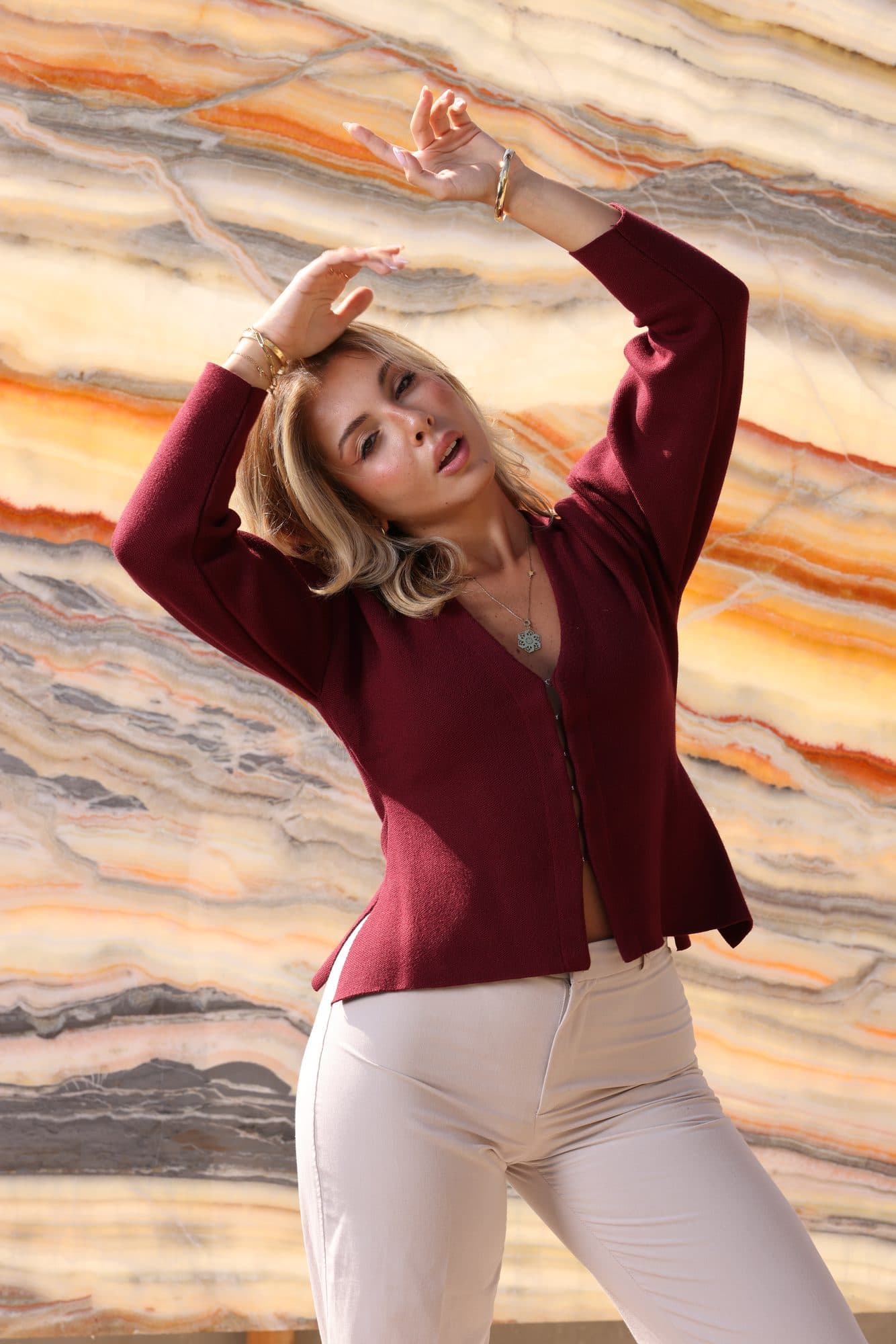 A figure in burgundy against banded orange onyx at the Zein Group yard
