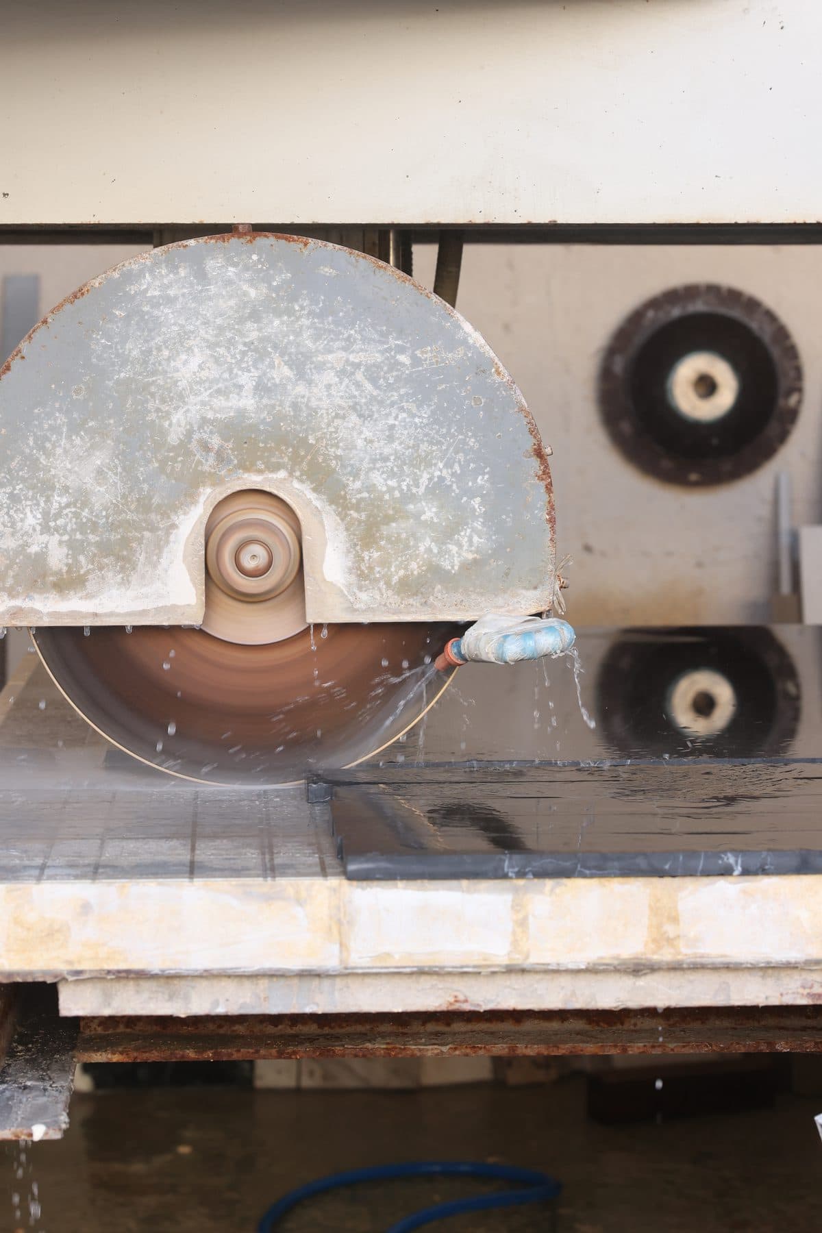 Bridge-saw blade cutting a natural stone slab at the Zein Group workshop in Beirut