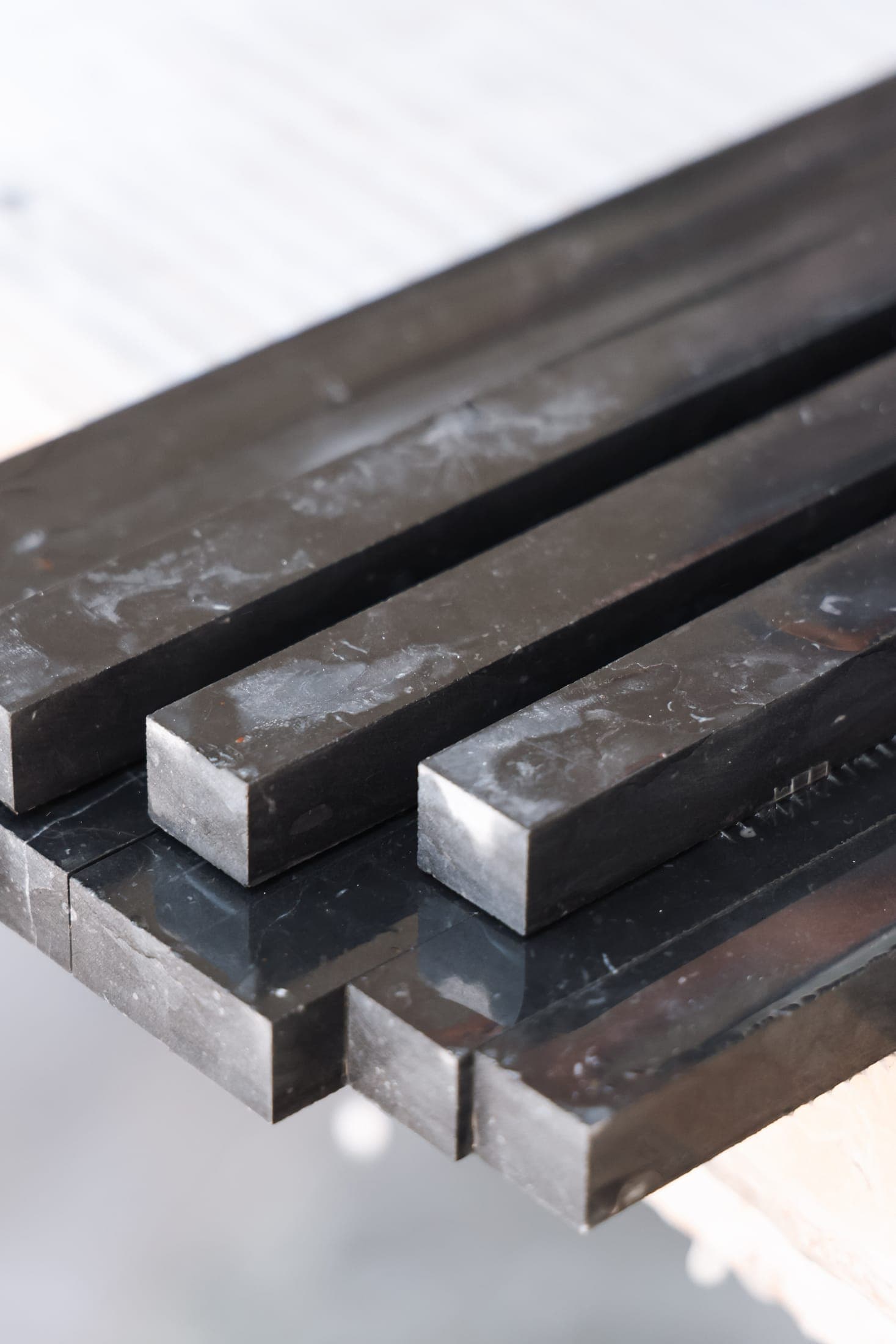 Freshly cut black marble strips stacked at the Zein Group workshop