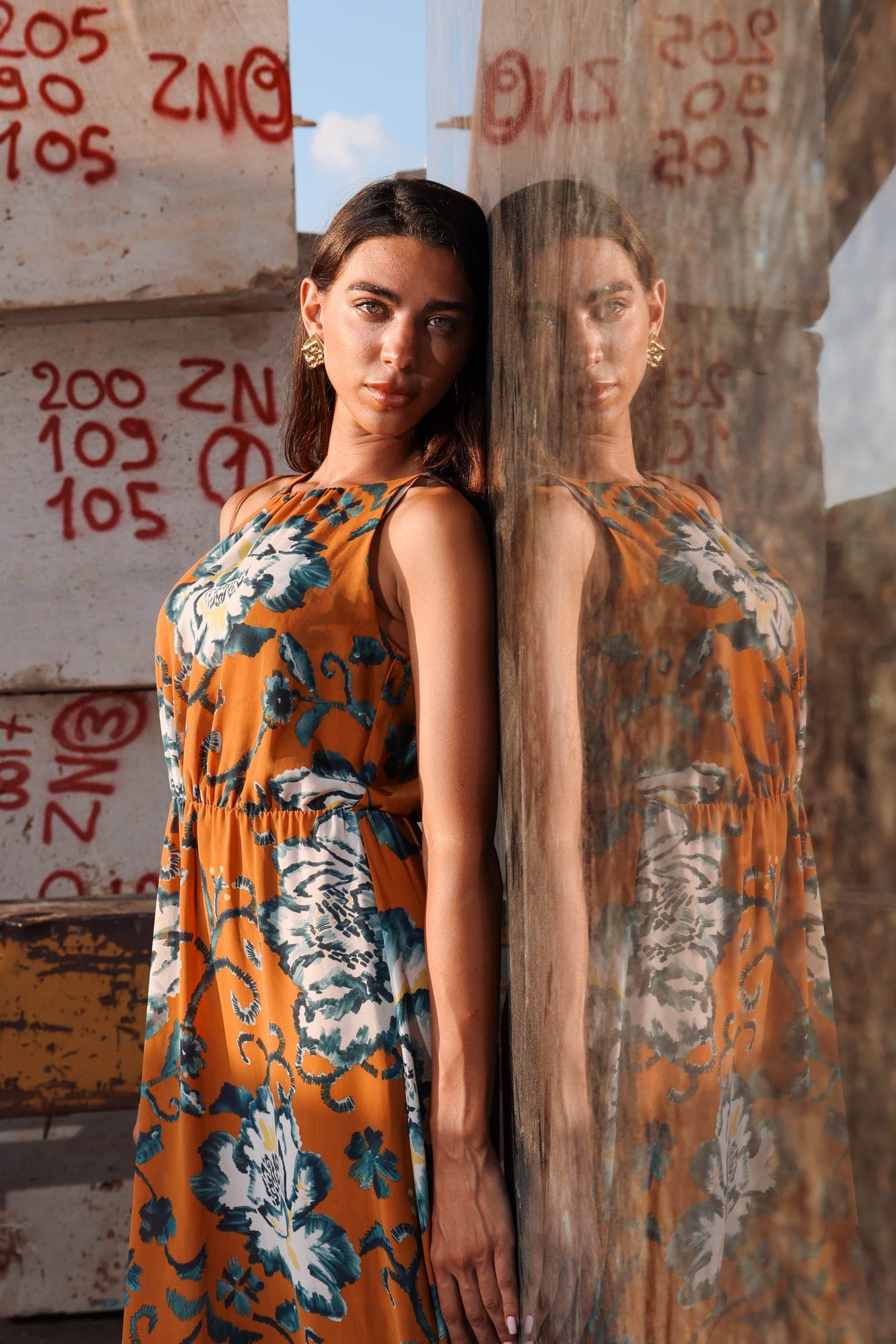 A figure and her reflection in a polished slab marked up for cutting